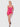 Woman wearing a pink lace nightgown against a white background