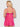 Woman wearing a pink lace nightgown against a white background