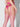 Person wearing pink lingerie and stockings on a plain background