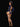 Woman wearing a navy blue lingerie set with a stewardess hat on a black background