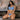 Violet Myers in blue lingerie sitting on a couch with abstract art in the background