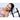 Woman wearing a pink bra with a white pillow and wand harness on a light blue background