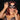 Woman wearing a black cat-eye mask against a dark background