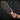 Person holding a boot print paddle against a black brick wall