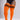 A model wearing bright orange ribbed thigh-high socks with three black stripes near the top, paired with a black bodysuit against a light gray studio background.