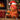 Teddy bear in Christmas-themed costume with holding candy cane and flogger with a gift, and fireplace in background