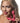 Woman holding a pink clitoral toy with a neutral background