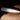 Chakrubs Prism Original Clear Quartz Wand on a dark surface