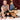 Man and woman in a sensual pose on a bed with dim lighting