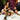 Two women in black lingerie with one using a feather tickler on the other on a bed.