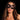 Woman wearing a black mask against a dark background