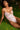 Woman wearing a pink bodysuit on grass