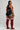 Person wearing black athletic top and shorts with red knee-high socks on a plain background