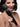Woman holding a black wand vibrator with a plain background