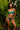 Woman wearing a teal lingerie set in a tropical setting with green foliage.