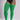 A model wearing bright green ribbed over-the-knee socks or thigh-high stockings, paired with a black bodysuit, shown against a light gray studio background.