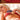 Woman in red bra holding The Tickler Vibrating Silicone Tickler.