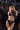 Model wearing black lingerie with 'Playboy' branding against a reflective black background