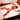 Woman in red lingerie lying on a bed with white sheets