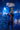 Person in a glamorous costume standing in a dimly lit room with a chandelier.