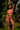 Woman in a pink lingerie standing in a lush green outdoor setting