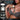 Product advertisement for 'Jizz' with a woman applying cream to her skin, against a brick wall background.