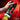 Hand holding a black and red JOCK Gyroblast Rechargeable Masturbator against a fiery background