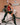 Person in a hospital room wearing a black and red outfit with high boots.