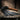 Black leather flogger with wooden handle on a wooden surface, Master Series branding visible.