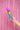 Le Wand Rainbow Ombre Petite wand massager held up against a pink iridescent curtain