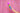 Hand holding the Le Wand Rainbow Ombre Petite in front of a shimmery pink backdrop