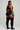 Person wearing a black athletic outfit with white trim on a plain background