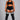 A plus-size model stands against a neutral gray studio background wearing a black athletic crop top, black shorts with white side stripes, sheer black thigh-high stockings with white stripes near the top, and black tights.
