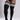 Black ribbed thigh-high socks with three white stripes near the top, shown on a model wearing black bodysuit and tattooed legs against a light gray studio background.