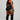 Person wearing black athletic outfit with orange stripes on a plain background