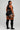 Person wearing black athletic outfit with orange stripes on a plain background