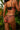 Woman wearing a black and red floral lingerie set against a blurred natural background