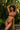 Woman in a floral bra set standing against a tropical background