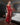 Woman in a red sequin dress with devil horns and tail in a room.