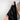 Person holding a black blanket against a light gray wall