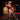 Woman in a red outfit on St. Andrew's Cross with Sex Machine in a dimly lit room with brick walls.