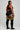 Person wearing black athletic outfit with yellow stripes on a gray background
