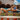 Woman lying by a pool holding a blue Fleshlight Turbo with a colorful tiled pool deck and building in the background.